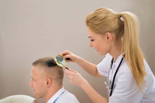 Mulher examinando paciente para saber implante capilar resultados